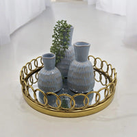 Blue ceramic vases with gold accents on a gold ring tray, styled with greenery for modern home décor
