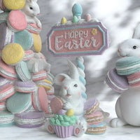 Pastel Easter bunny figurine with macarons, cupcake, and 'Happy Easter' sign for spring home décor