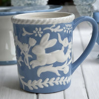 Blue ceramic mug with white rabbit and floral relief design, vintage home decor accent