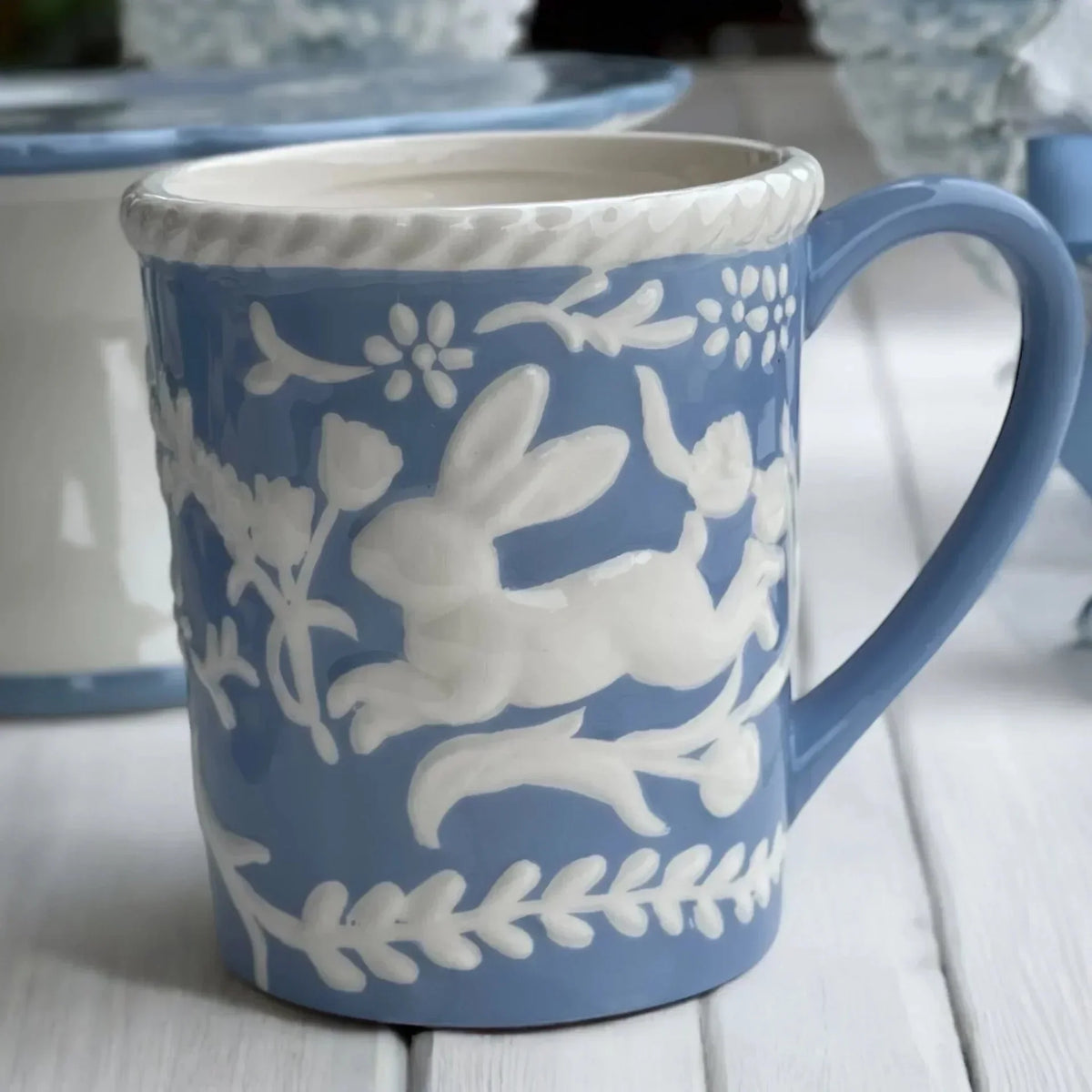 Blue ceramic mug with white rabbit and floral relief design, vintage home decor accent