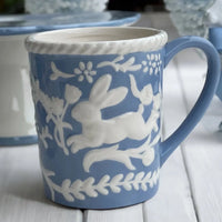 Blue ceramic mug with white rabbit and floral relief design, vintage home decor accent
