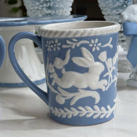 Blue ceramic mug with white embossed bunny and floral design, perfect for vintage home décor