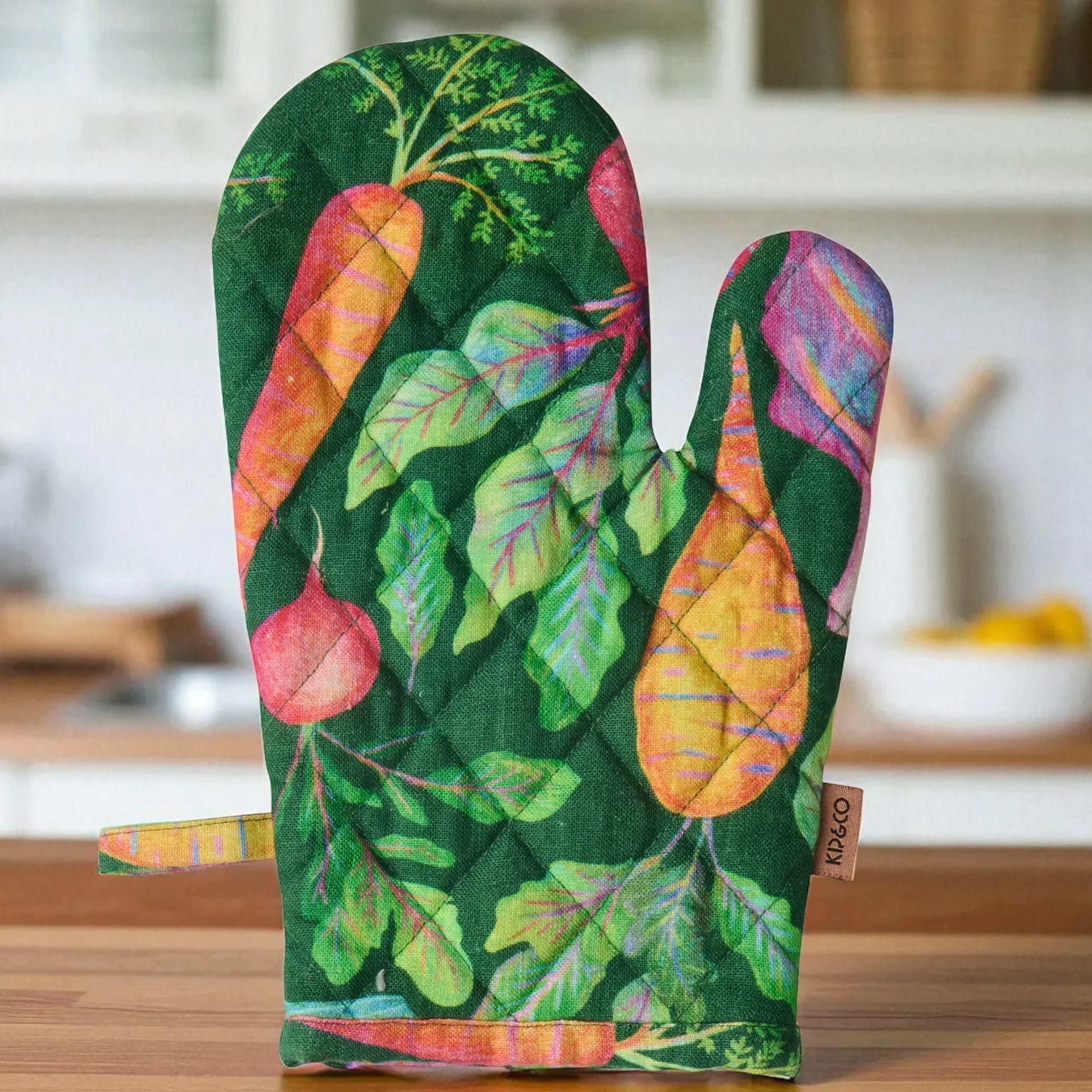 Colorful vegetable print oven mitt with quilted design, perfect for kitchen decor and cooking safety.