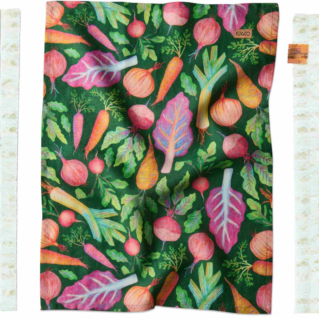 Colorful vegetable print kitchen towel with carrots, beets, and onions on dark green background
