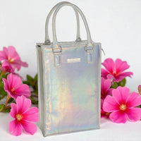 Iridescent silver handbag with top handles, styled with pink flowers for elegant home décor