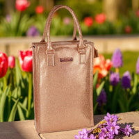 Sparkling rose gold tote bag with 'Luxury Australia' plaque, set against vibrant garden blooms for elegant home décor.