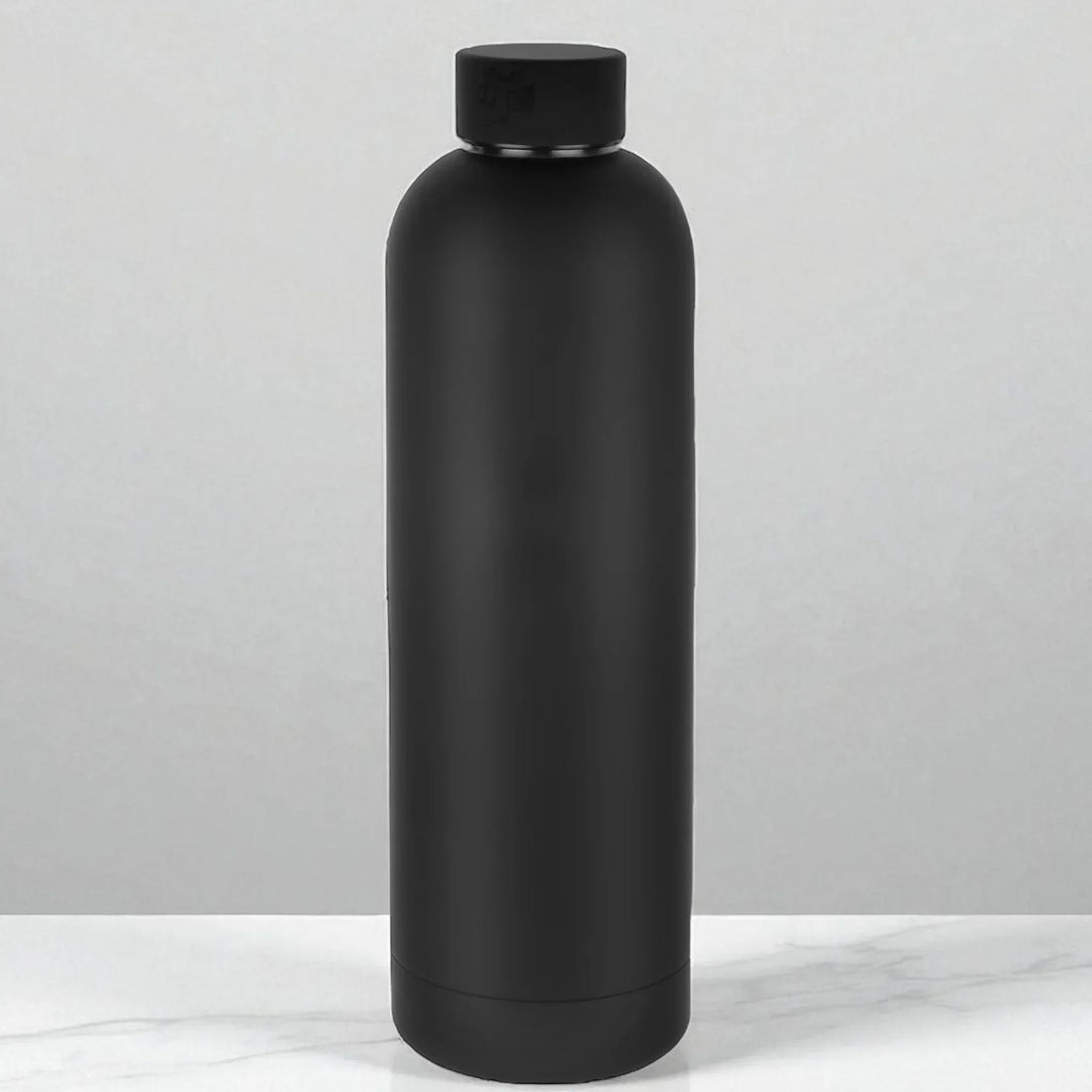 Matte black insulated water bottle on marble surface, modern home accessory