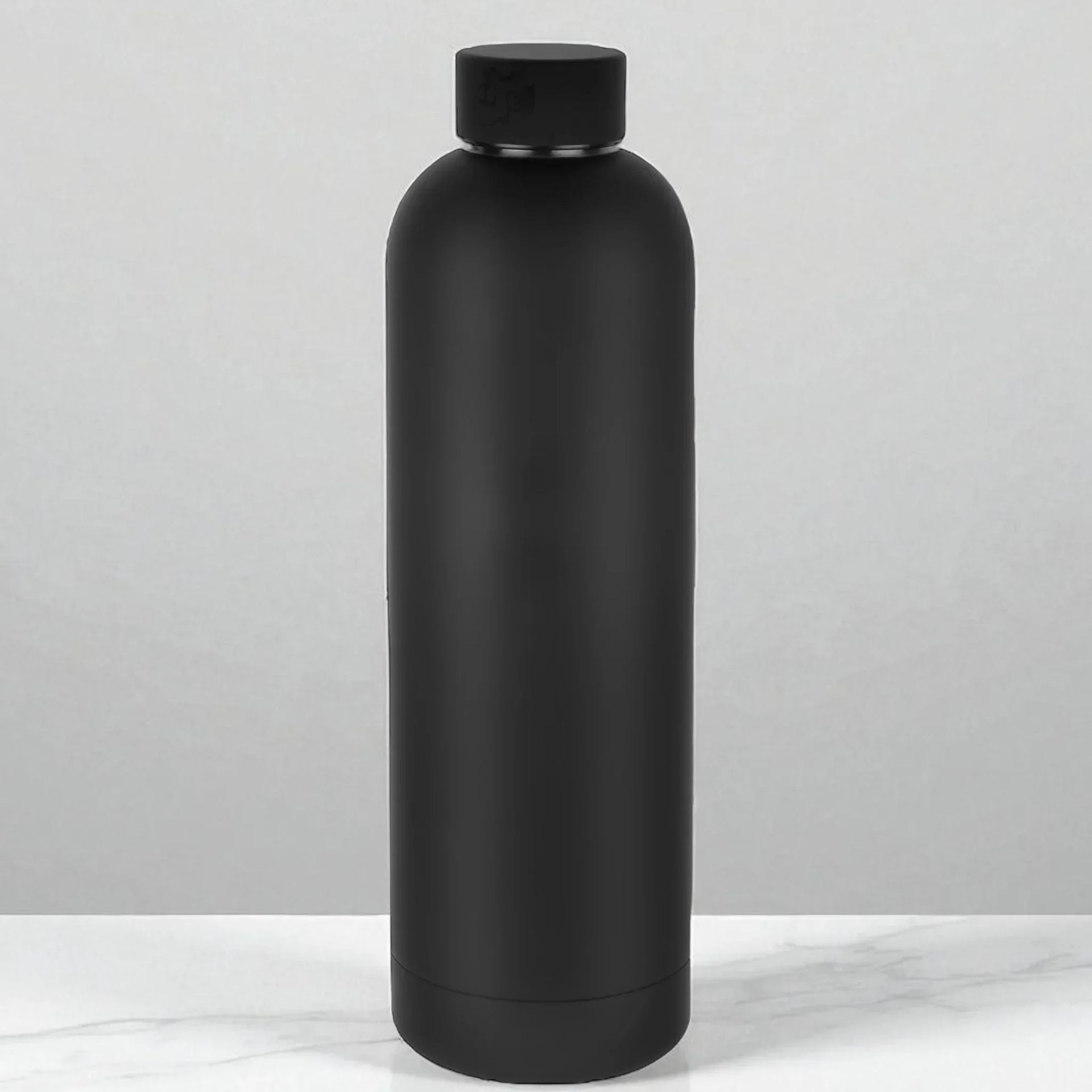 Matte black insulated water bottle on marble surface, modern home accessory