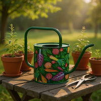 Colorful vegetable-patterned watering can on garden table with potted plants and pruning shears