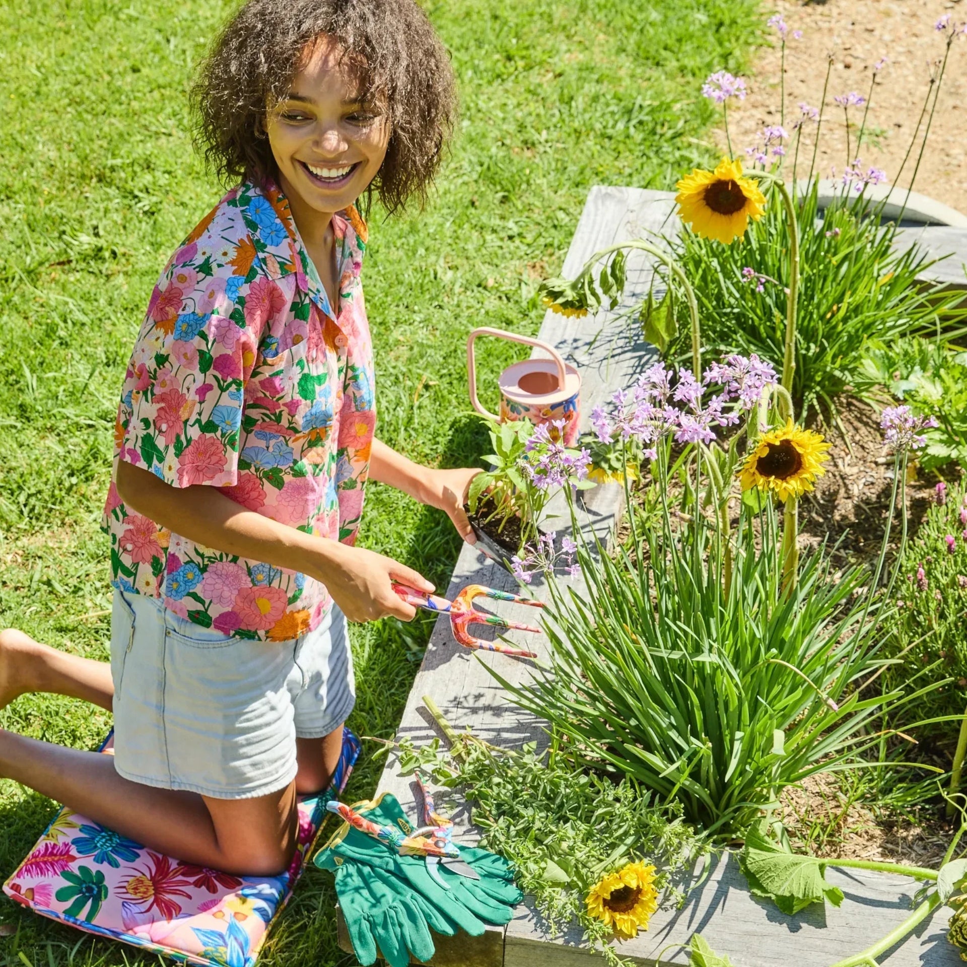 Woman gardening with colorful floral tools, sunflowers, and garden accessories in a vibrant outdoor setting