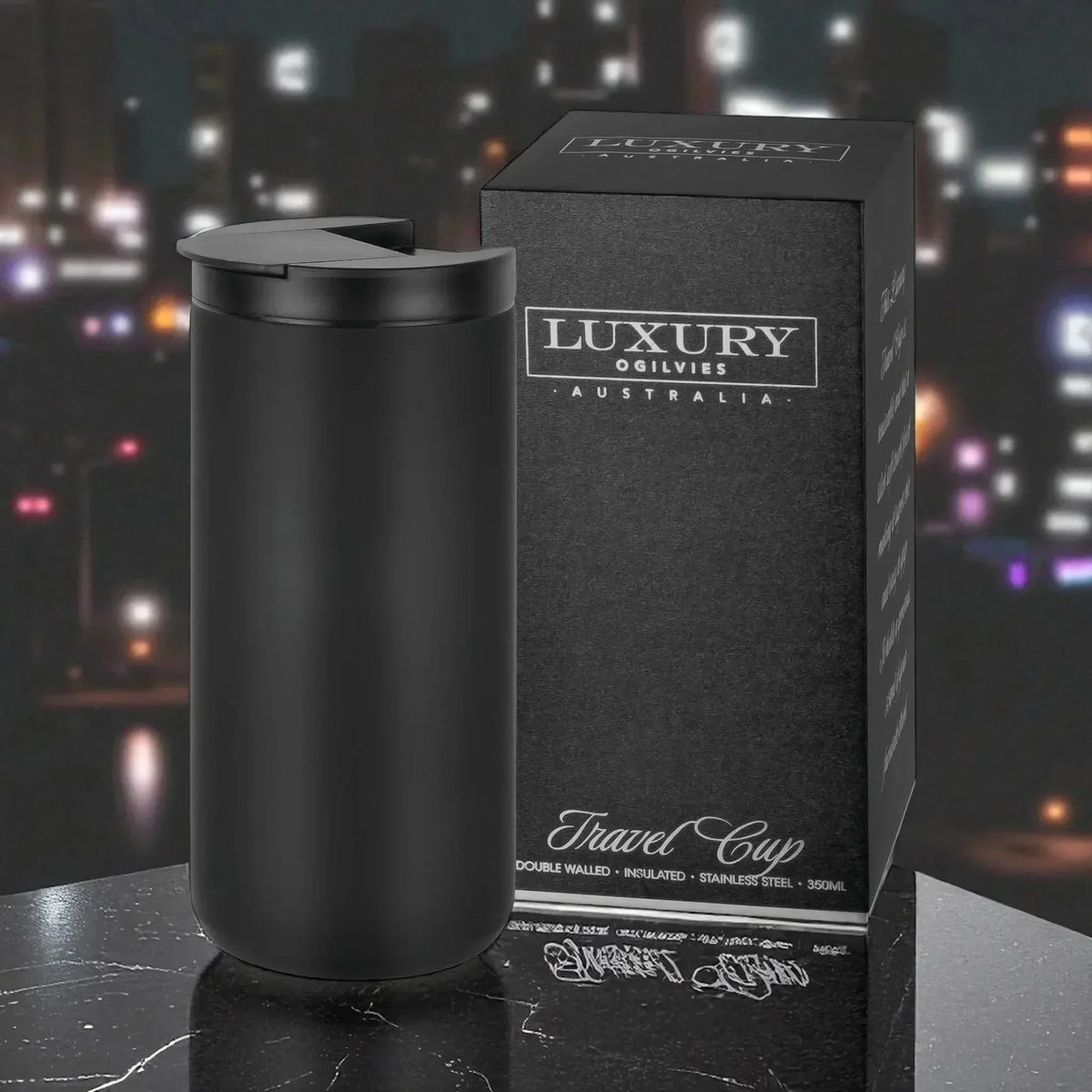 Black insulated travel mug with lid, stainless steel, 350ml, next to luxury packaging on marble surface