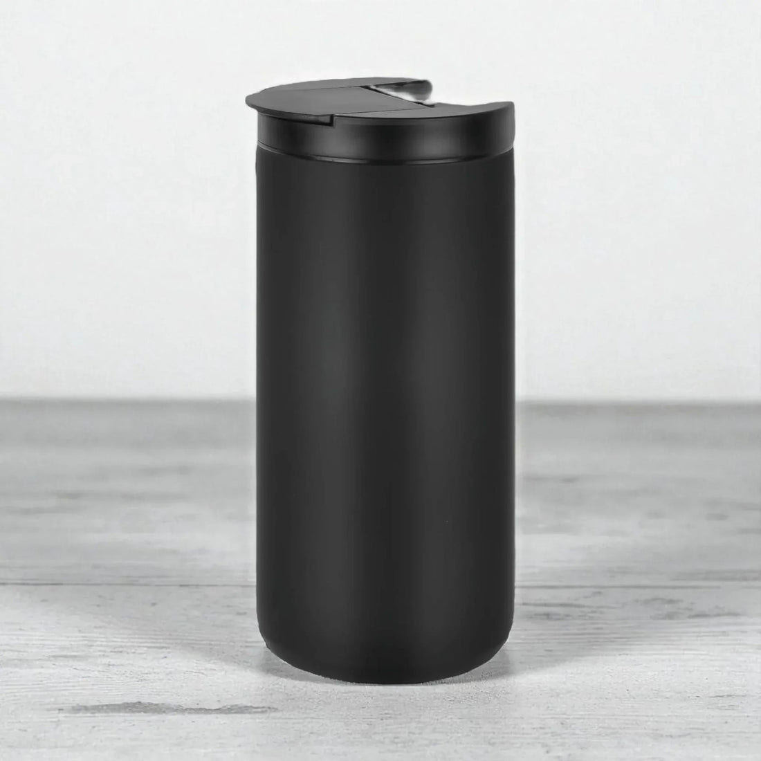Matte black travel mug with spill-proof lid, modern home accessory for everyday use