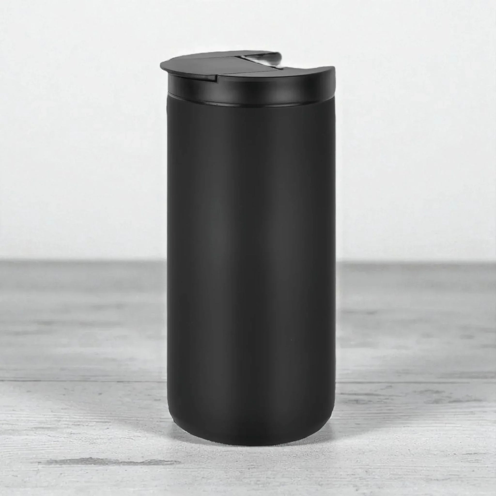 Matte black travel mug with spill-proof lid, modern home accessory for everyday use
