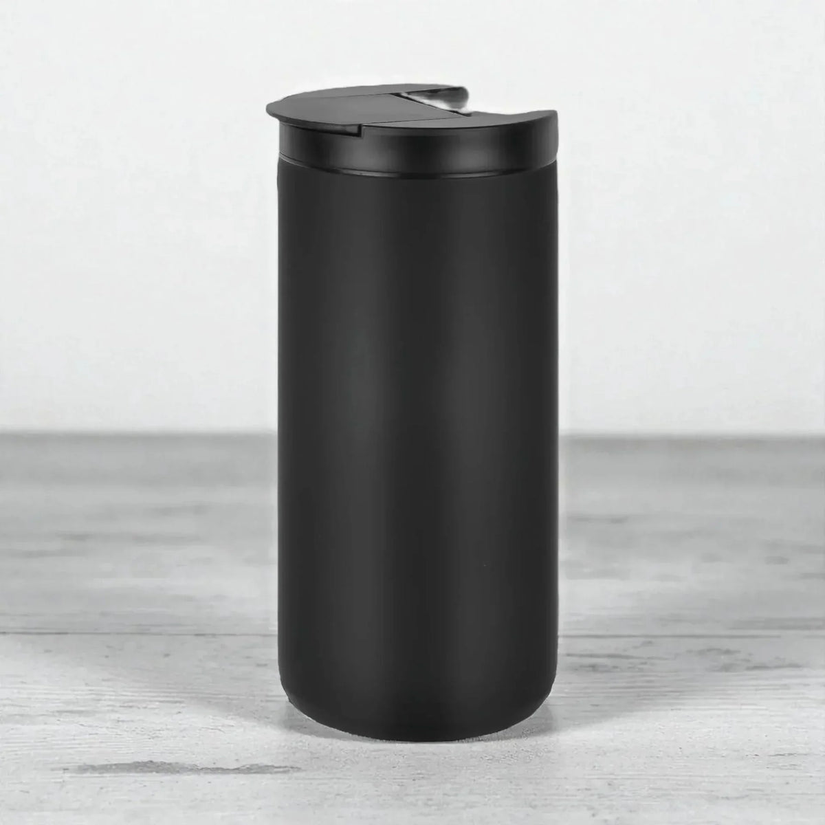 Matte black travel mug with spill-proof lid, modern home accessory for everyday use