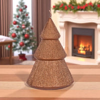 Glittery gold Christmas tree candle on wooden table, festive holiday decor with fireplace and tree background