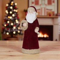 Velvet Santa Claus figurine with gold trim, holding wreath and bell, festive holiday decor for home