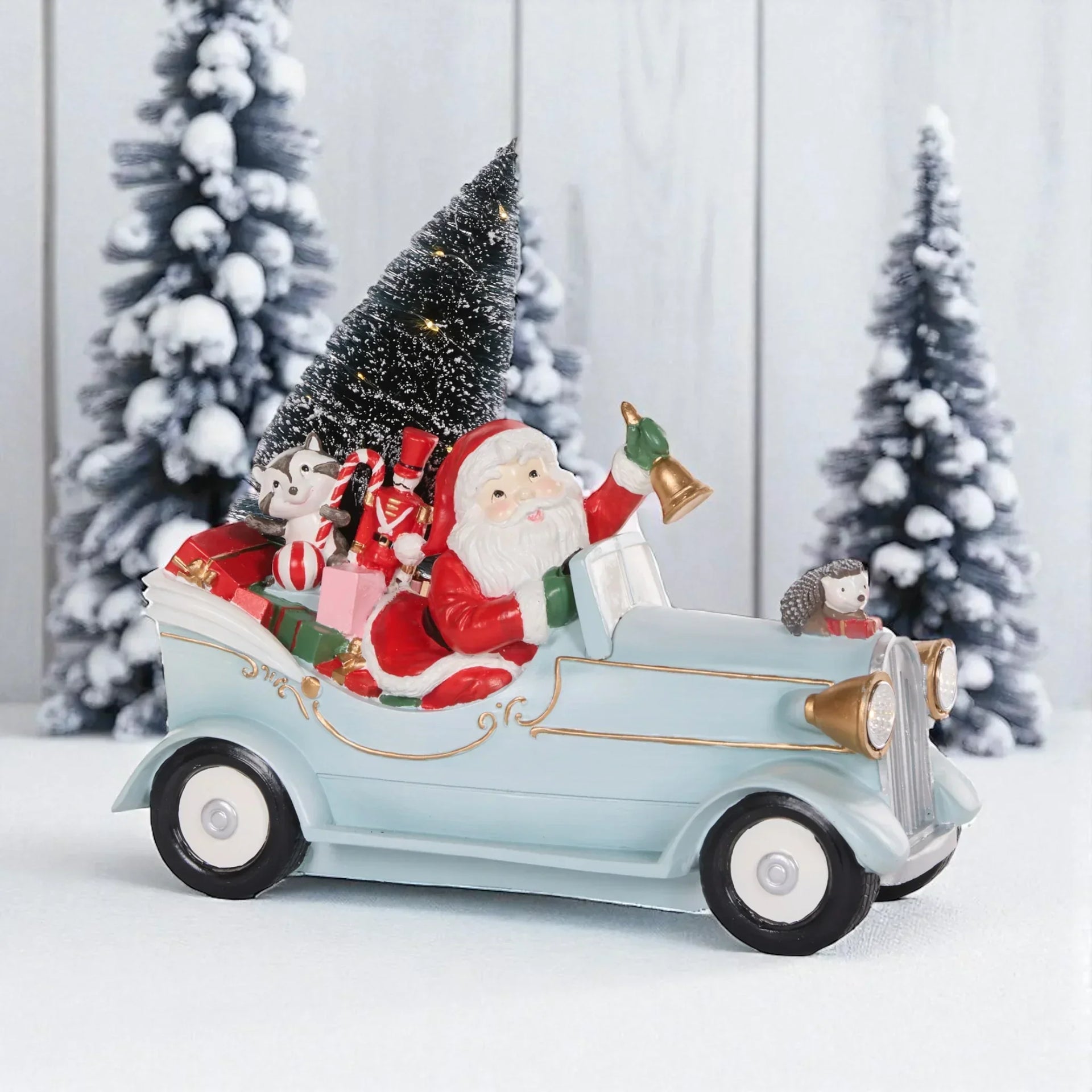 Santa in vintage car with gifts, Christmas tree, and festive animals for holiday décor