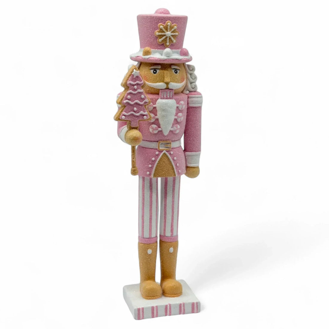 Pink glitter nutcracker holding gingerbread tree, festive holiday décor with striped legs and gold boots