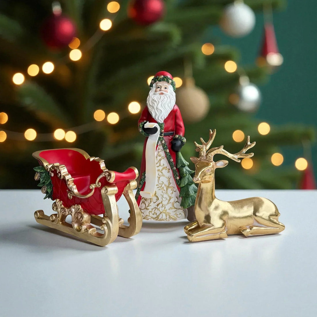 Santa figurine with red sleigh and gold reindeer, festive Christmas decor against lit tree