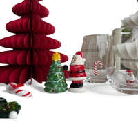 Ceramic Santa figurine beside green Christmas tree with red paper tree and candy canes