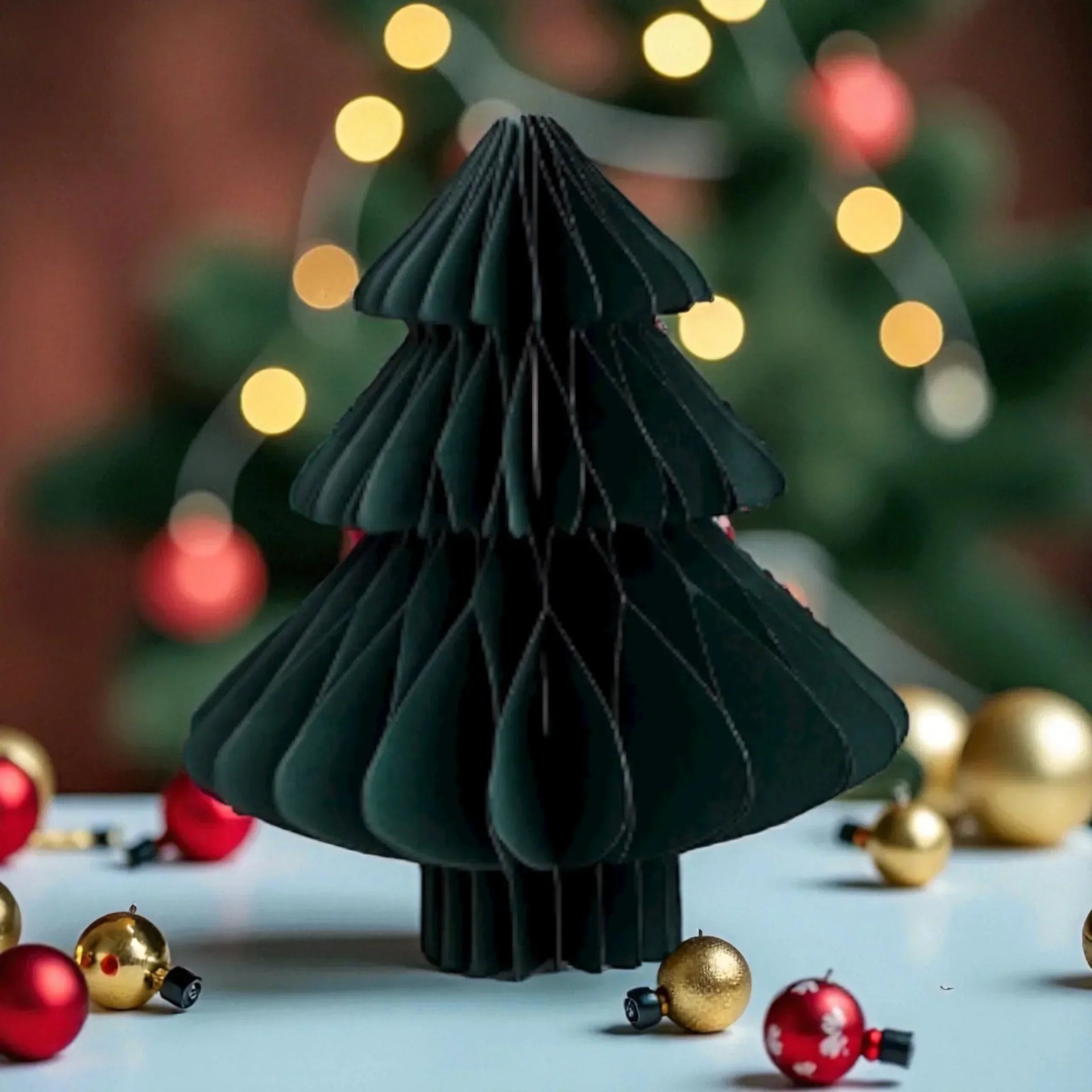 Modern black paper Christmas tree decoration with red and gold ornaments, festive holiday home décor