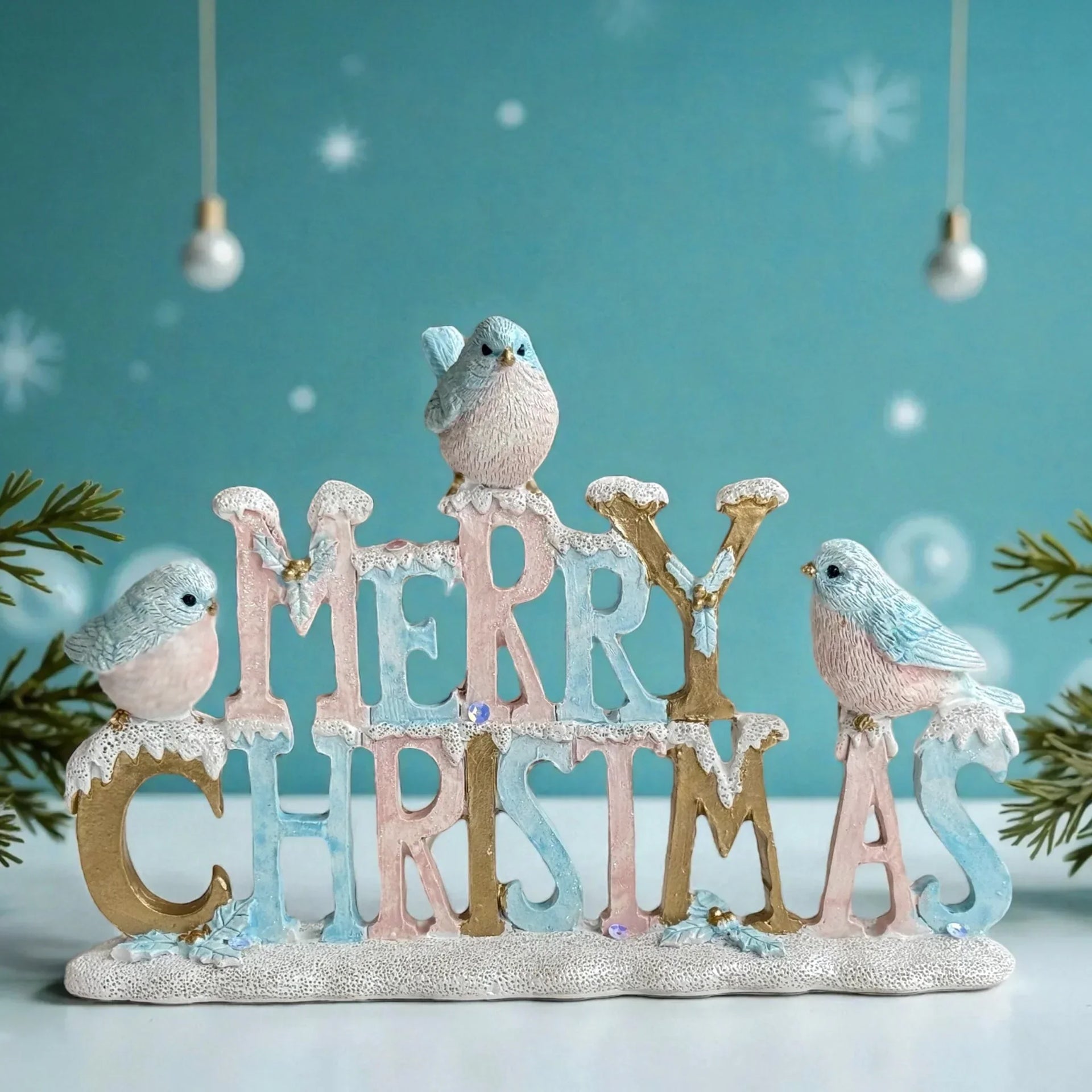 Merry Christmas sign with pastel birds, snow-dusted letters, and festive holiday decor for home tabletop display