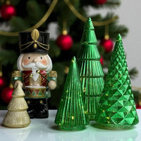 Nutcracker figurine with green and gold Christmas tree decorations, festive holiday home décor