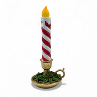 Red and white striped Christmas candle in gold holder with holly, festive home décor