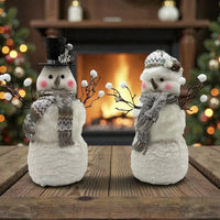 Charming snowman figurines with scarves and hats, perfect for cozy Christmas home décor near fireplace