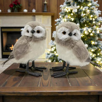 Fluffy grey and white owl figurines on wooden table, festive Christmas tree background, home décor accent