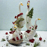Festive ceramic geese figurines with scarves, wreath, and Christmas tree, perfect for holiday home décor