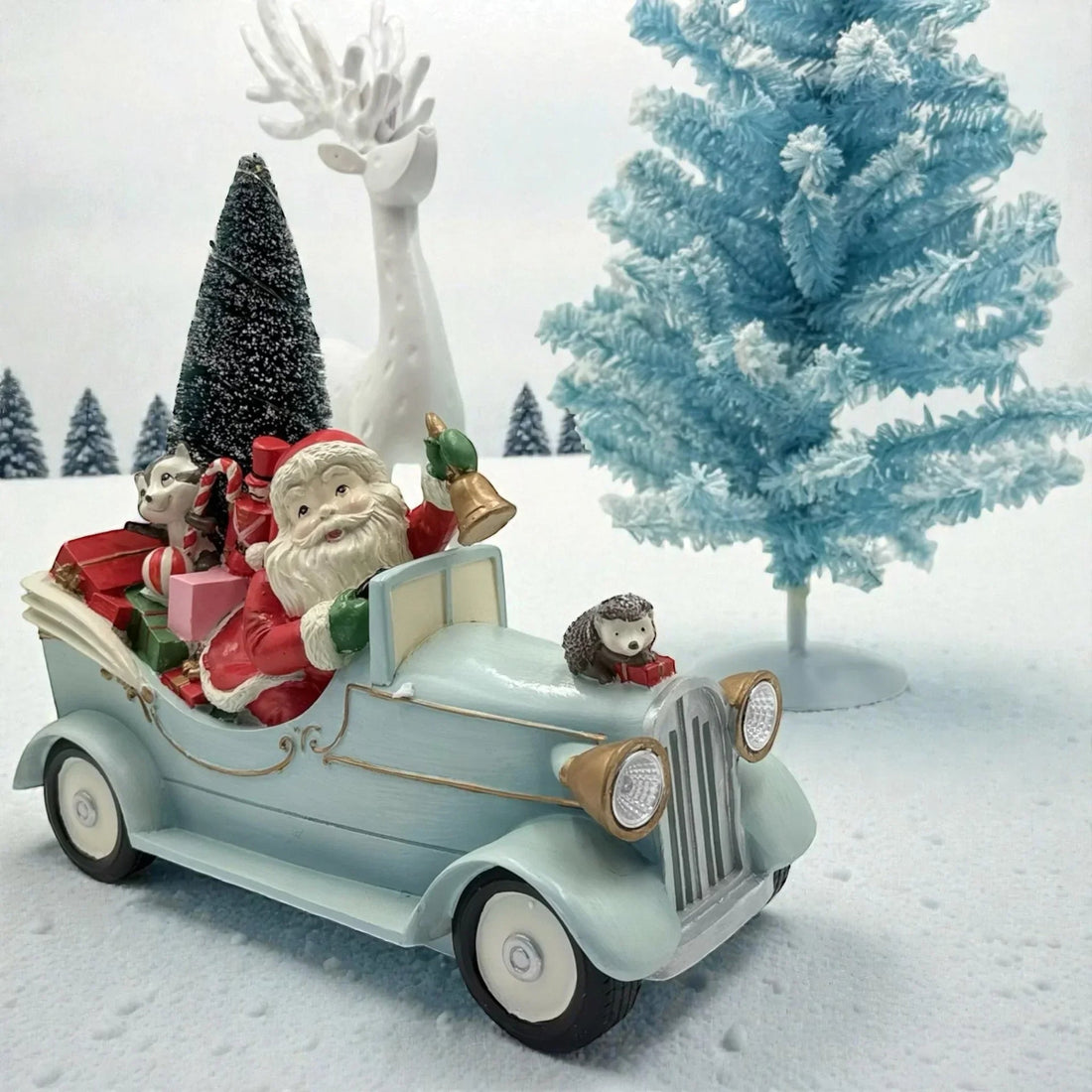 Santa in vintage car with gifts, hedgehog, and snowy Christmas tree decor