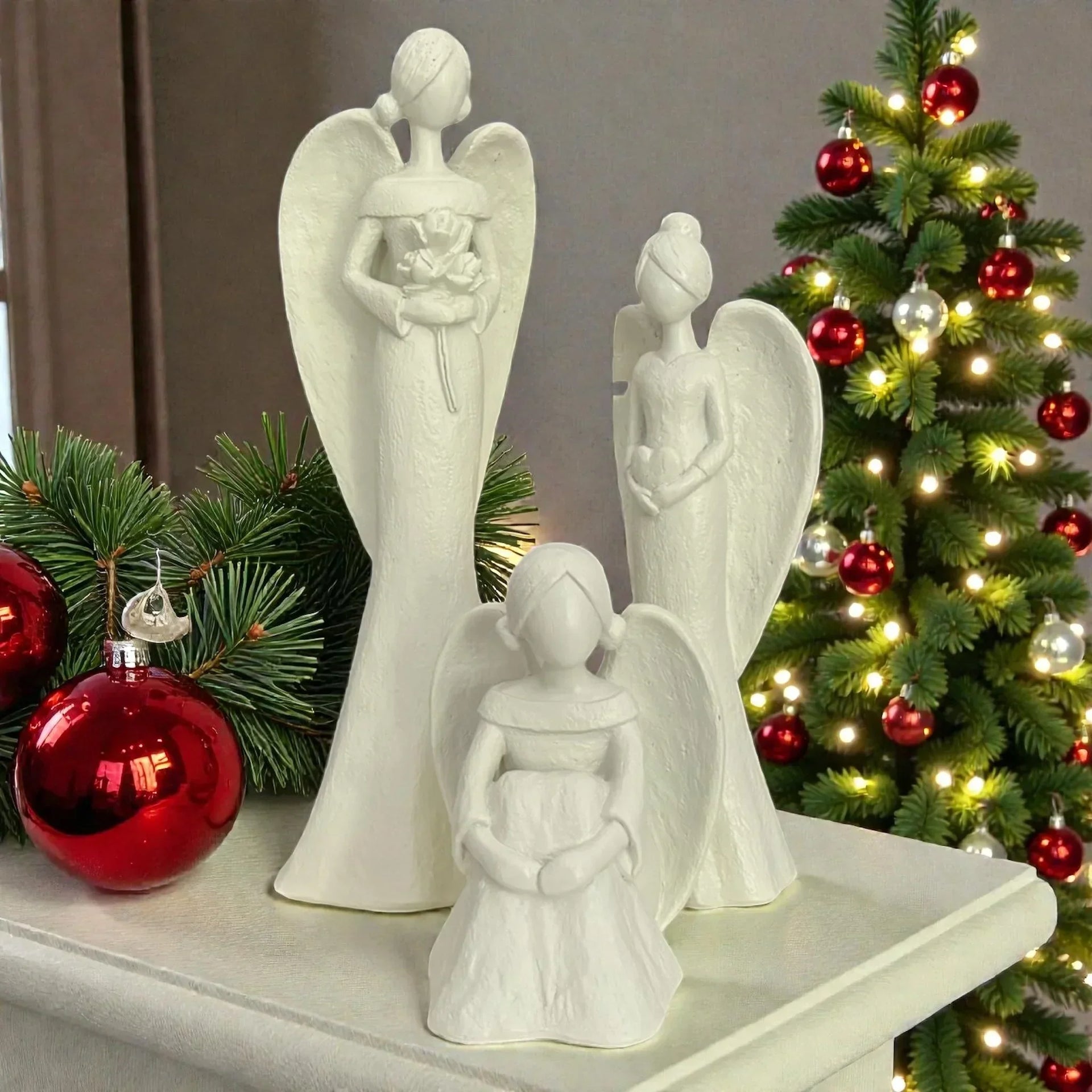 White angel figurines with wings, Christmas tree decor, red ornaments, festive home styling