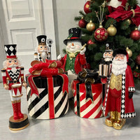 Festive Christmas decor featuring nutcrackers, Santa, snowman, and striped gift boxes near a decorated tree