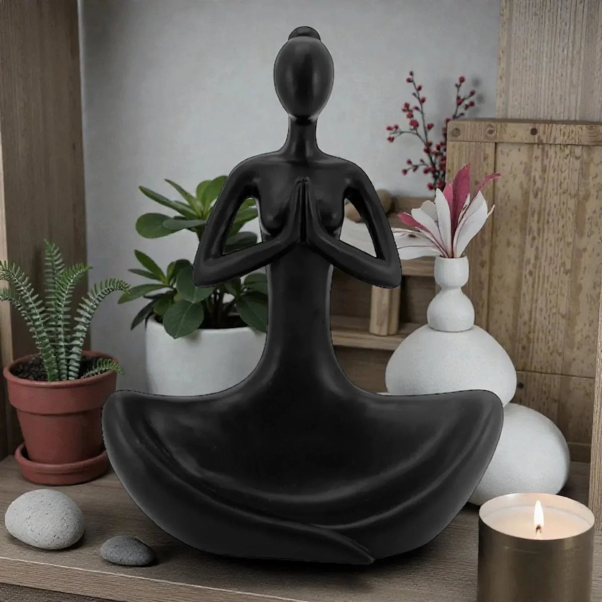 Black meditation statue for zen home décor with plants and candle