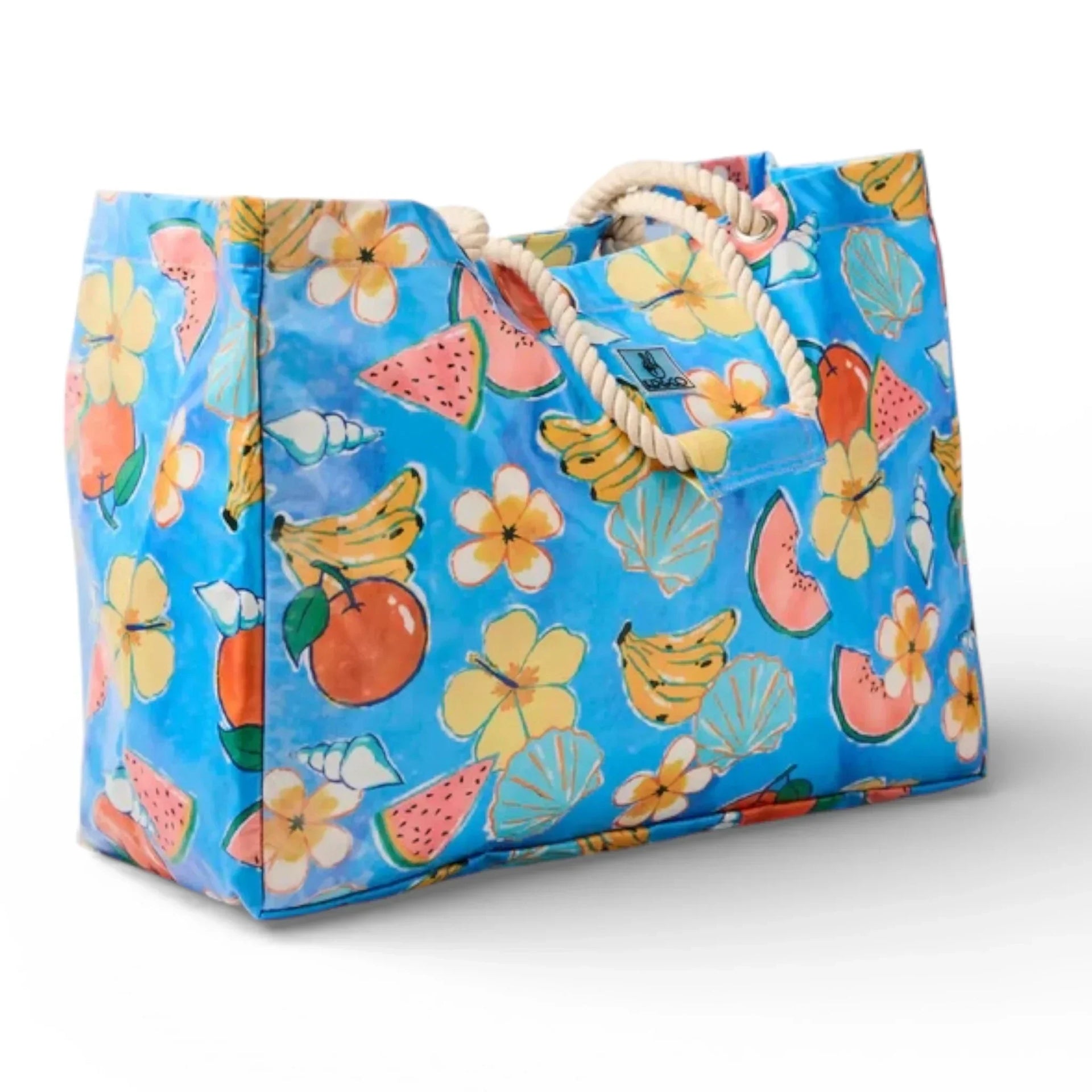 Blue tropical tote bag with fruit, flowers, shells, and rope handles for beach or market use