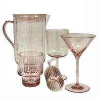 Pink ribbed glassware set with pitcher, tumblers, and martini glasses for elegant home entertaining