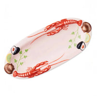 Ceramic seafood platter with lobsters, shells, lime, and herbs for elegant home dining