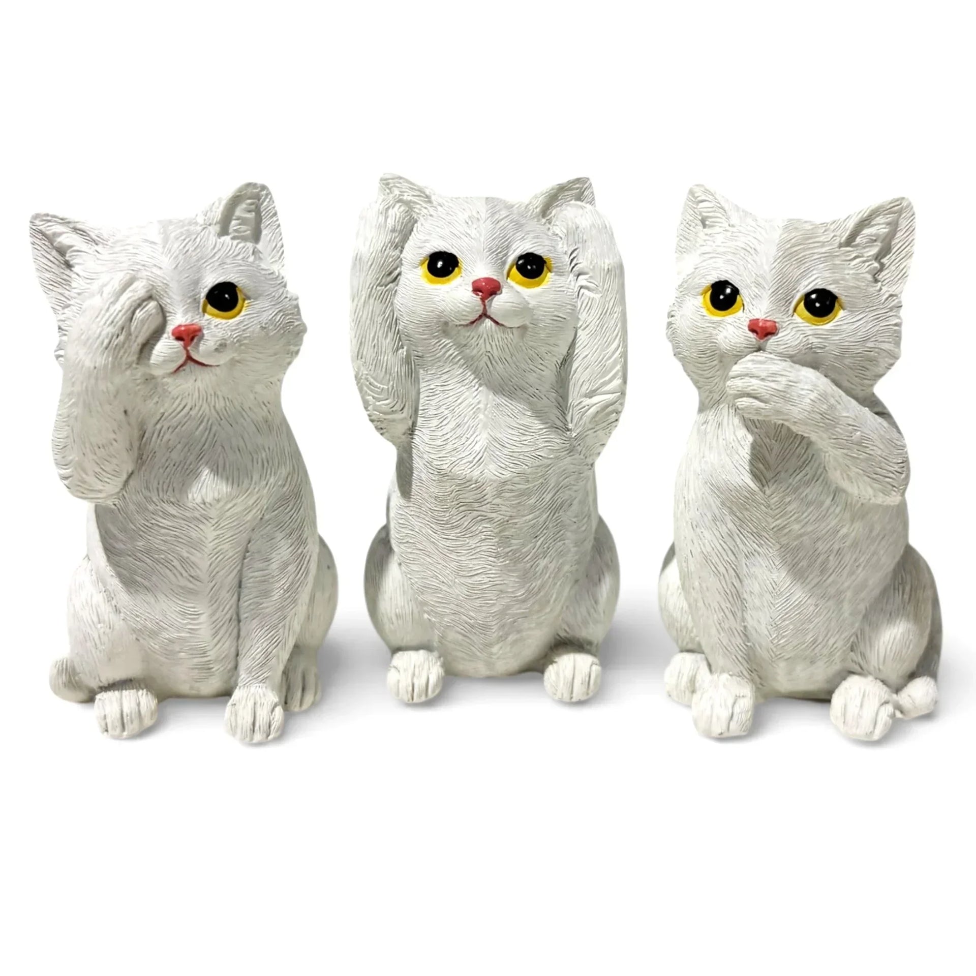 Three white cat figurines in see no evil, hear no evil, speak no evil poses for home décor