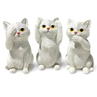 Three white cat figurines in see no evil, hear no evil, speak no evil poses for home décor