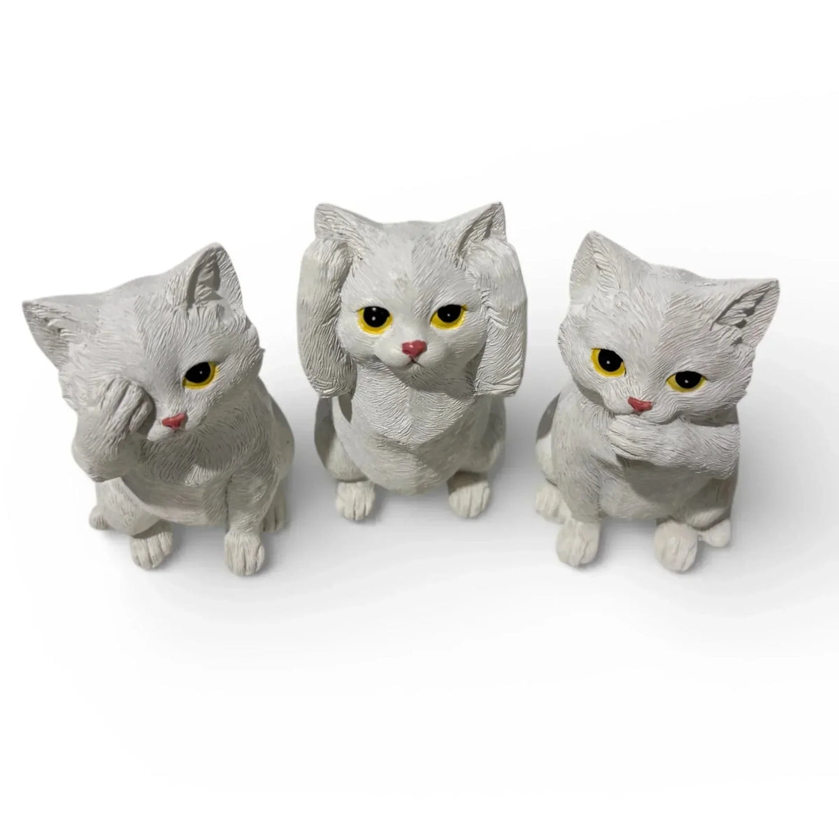 Three white cat figurines with yellow eyes, perfect for home décor or vintage-style interiors.