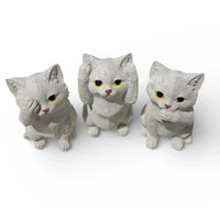 Three white cat figurines with yellow eyes, perfect for home décor or vintage-style interiors.