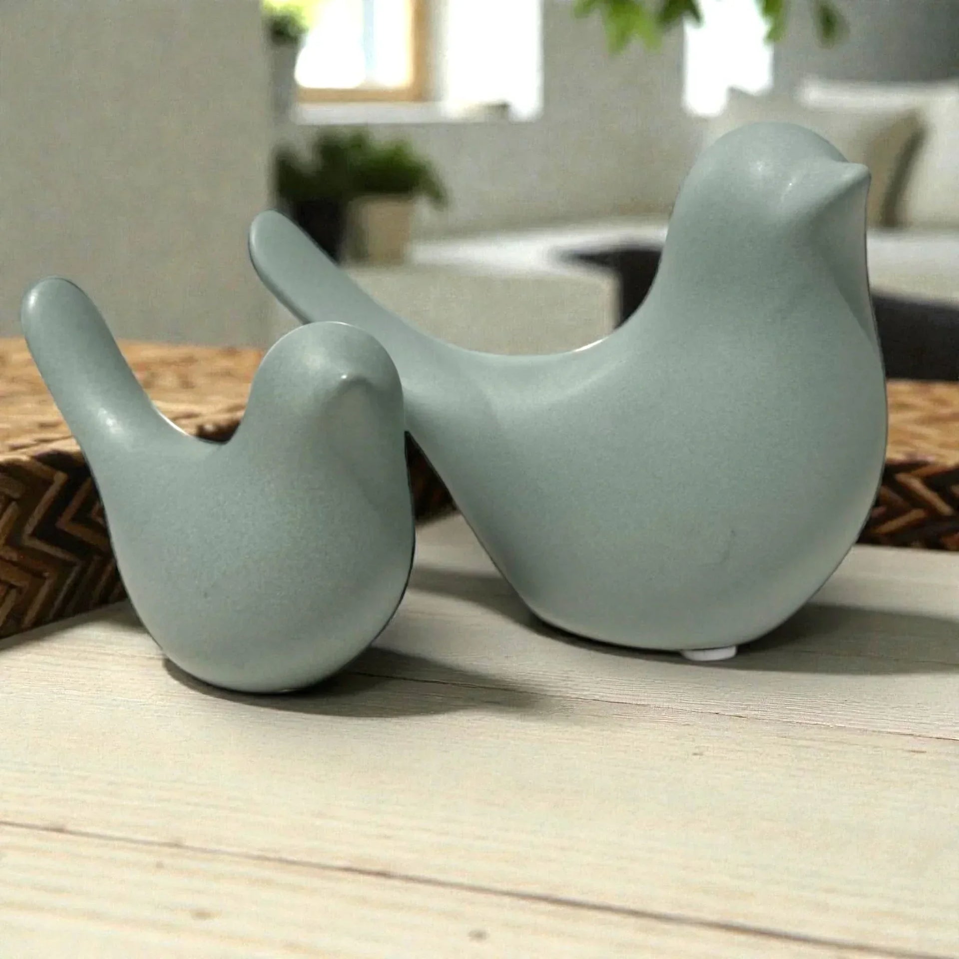 Sage green ceramic bird figurines for modern home décor, styled on wooden surface with woven mat