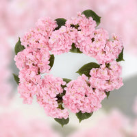 Pink hydrangea heart wreath with green leaves, perfect for home décor and vintage-style interiors.