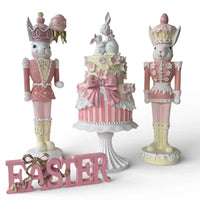 Pink Easter bunny nutcrackers with floral cake centerpiece and 'EASTER' sign, vintage home décor
