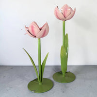 Pink metal tulip home décor with green stems and leaves, elegant indoor floral accent