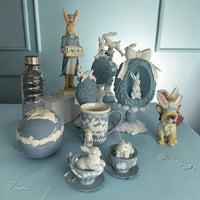 Easter bunny figurines, ceramic teacups, and blue decorative eggs for spring home décor