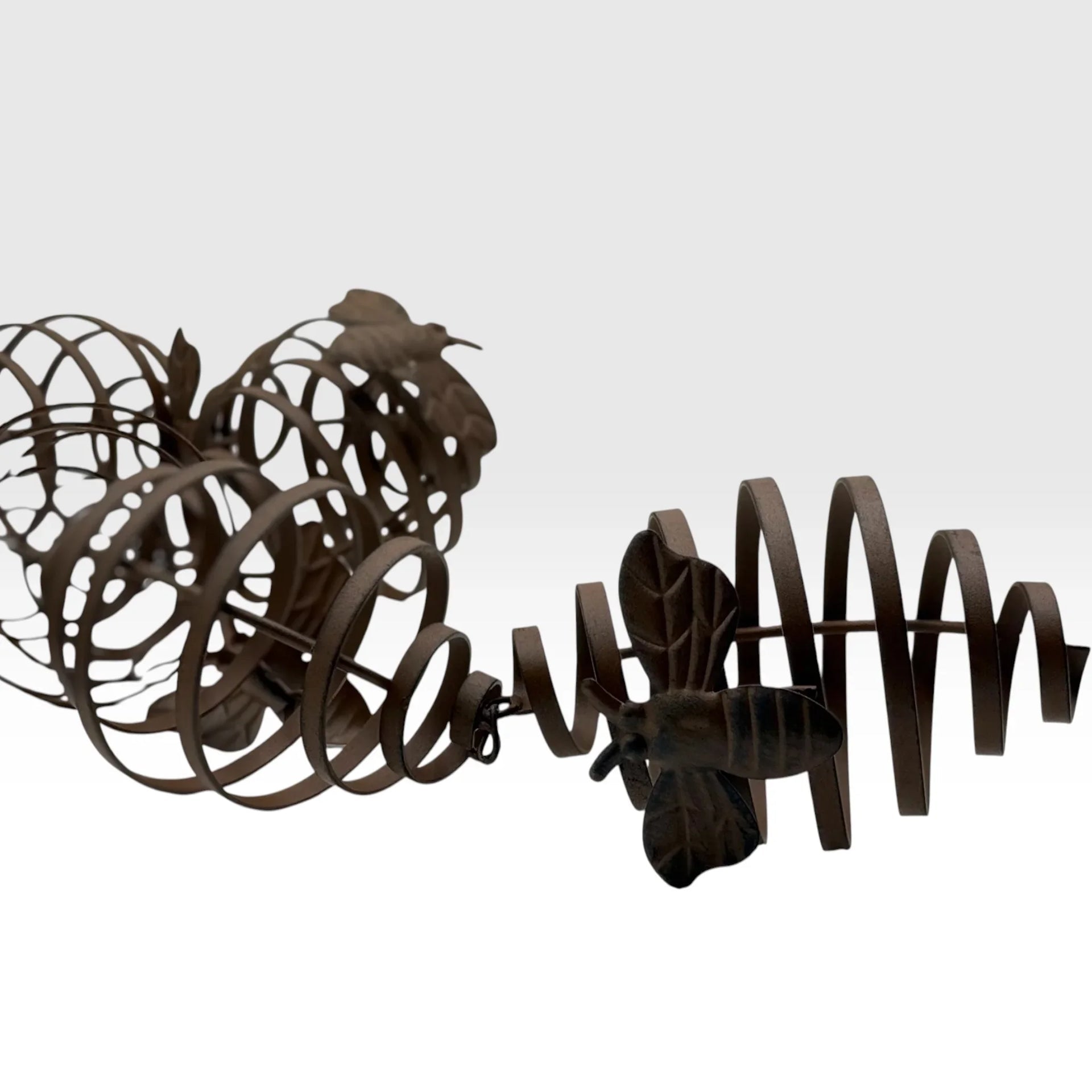 Rustic metal bee and bird garden sculpture with spiral design, perfect for outdoor décor and vintage-inspired spaces.