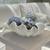 White ceramic shell bowl with blue floral decorative spheres, home décor accent piece