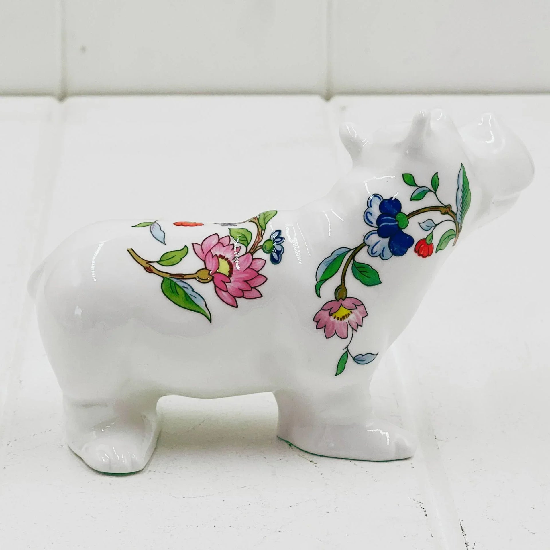 White ceramic hippo figurine with floral and berry designs, perfect for home décor